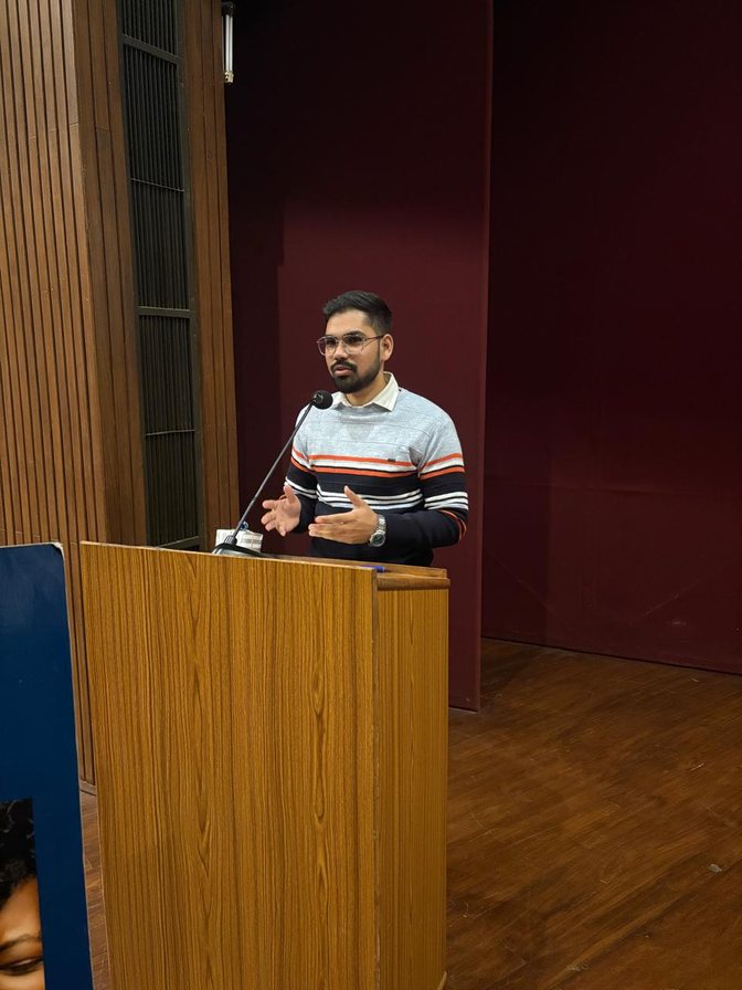 Anish presenting from a podium